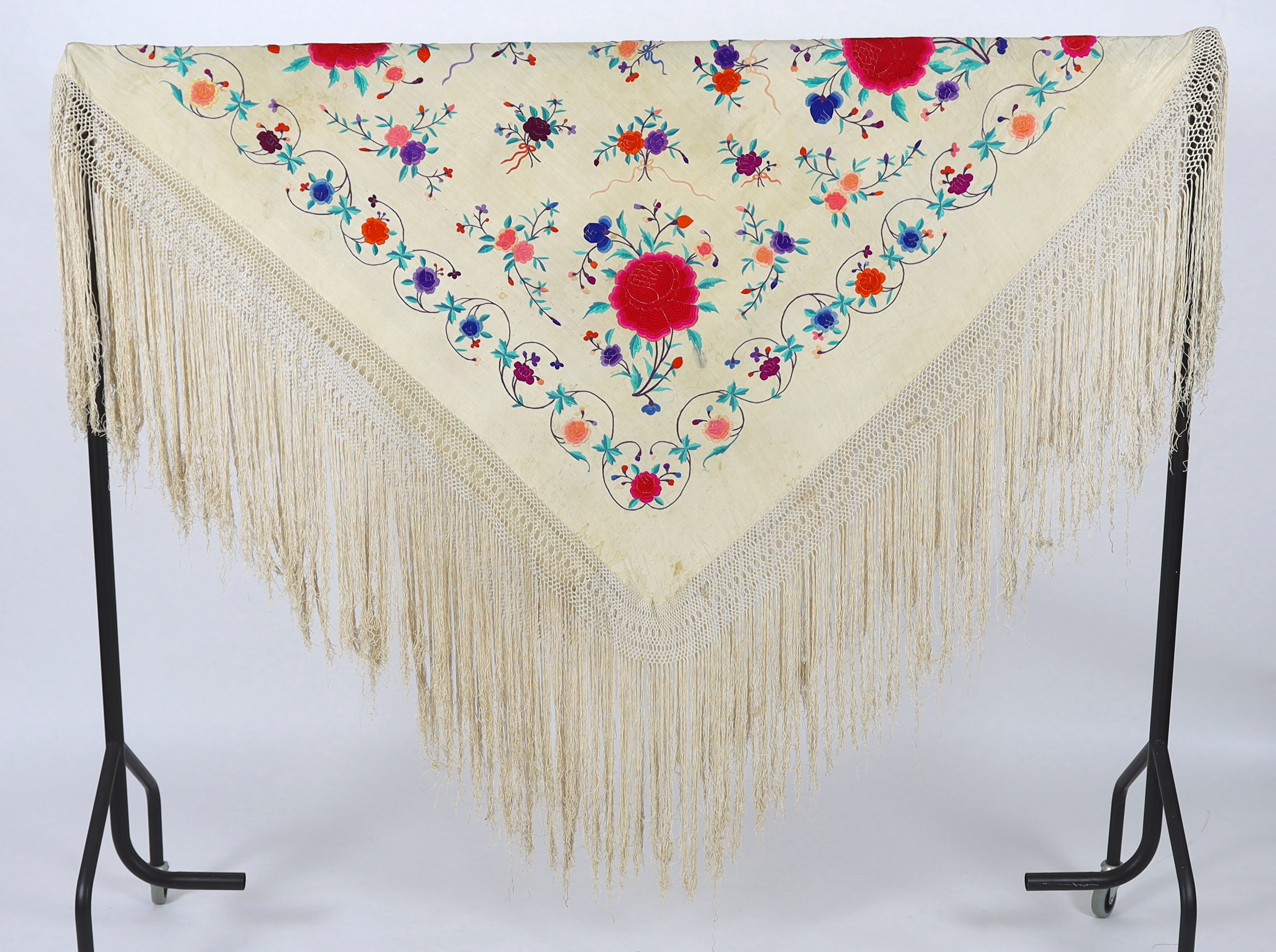 A late 19th / early 20th century cream silk fringed shawl, embroidered with all over polychrome silk floral motifs, 130 x 150cm not including fringe